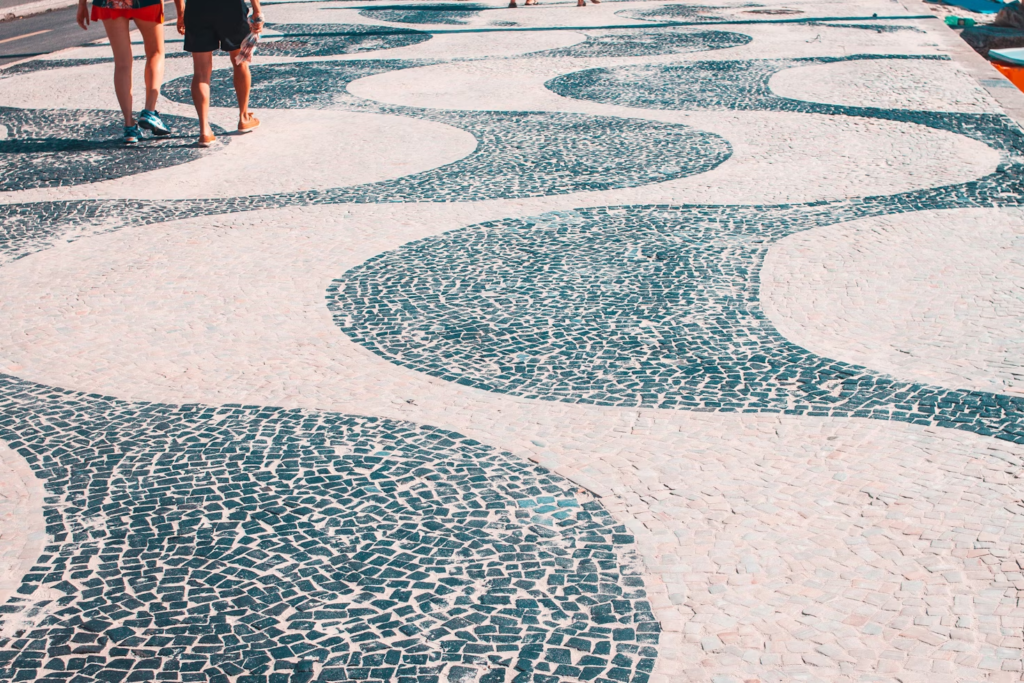 Praia de Copacabana o Paraíso Carioca Imperdível 5 Caçadão de Copacabana, foto diurna. Pessoas caminhando.