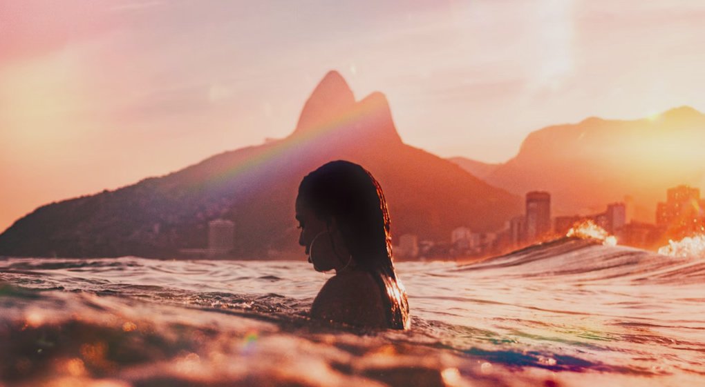Praia de Copacabana o Paraíso Carioca Imperdível 6 Por do sol em Copacabana, mulher na água. Paisagem de fundo.