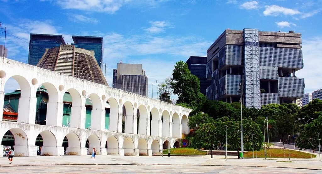 Arcos da Lapa: Um Símbolo Carioca de História e Cultura 1 Foto dos Arcos da Lapa, pessoas passando por baixo. Dia de Sol.