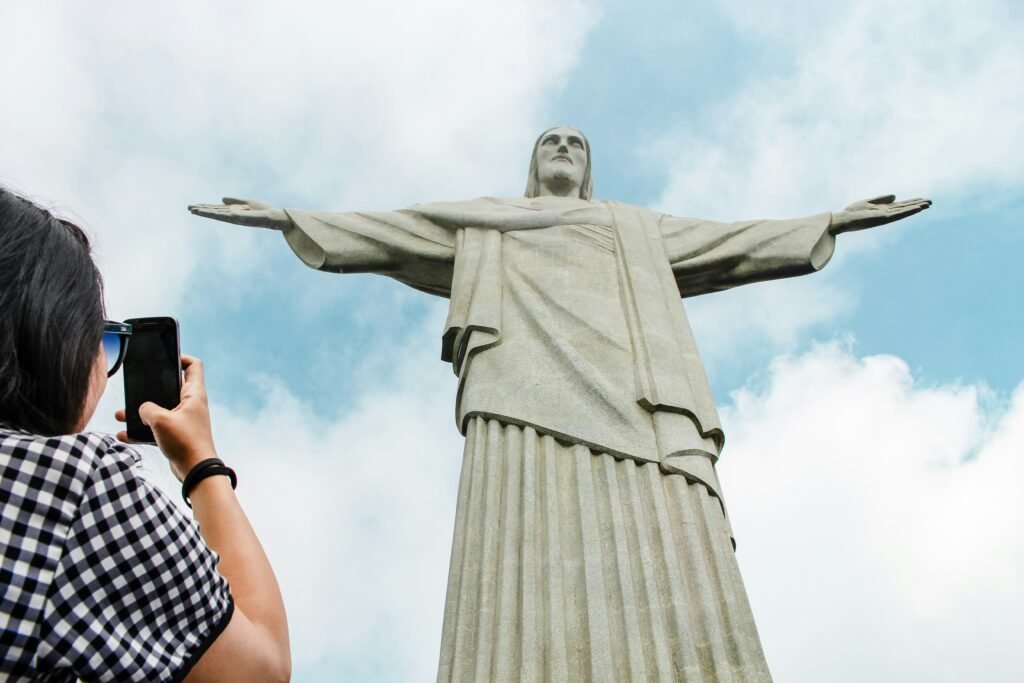 A Estátua do Cristo Redentor: Por que é um dos destinos mais procurados do mundo? 7 Mulher tirando foto do Cristo Redentor
