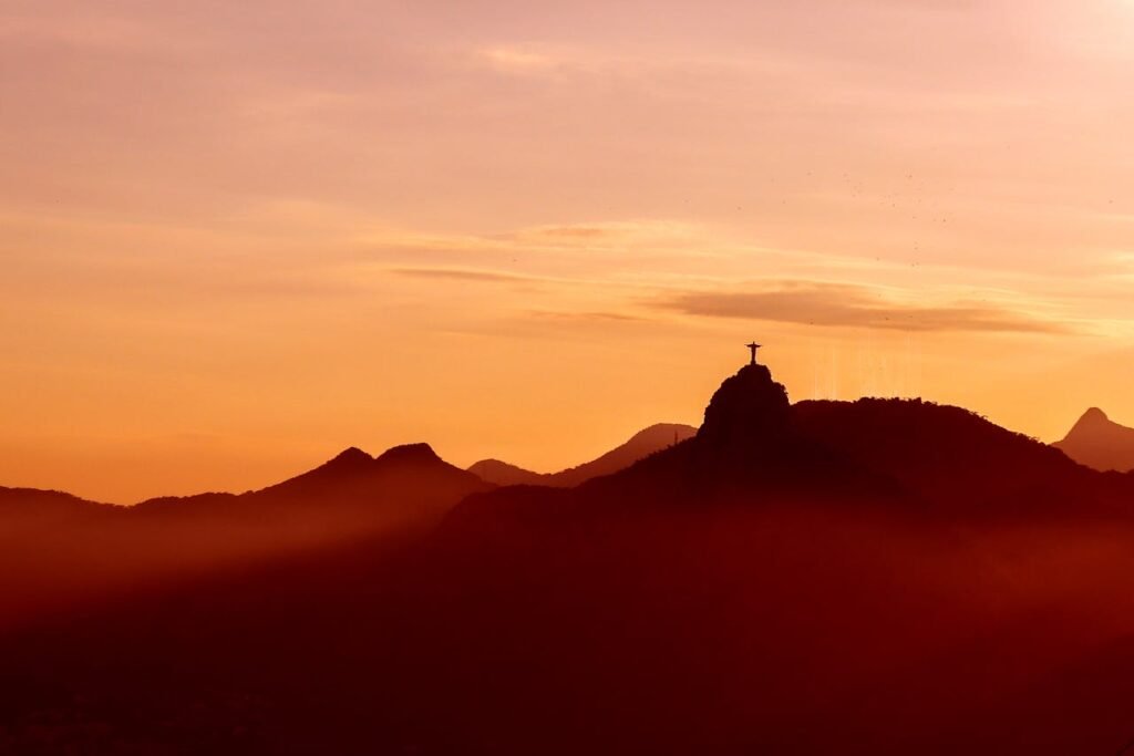 Cristo Redentor: O que você precisa saber antes de ir 3 Cristo Redentor, por do sol, estátua vista de longe.