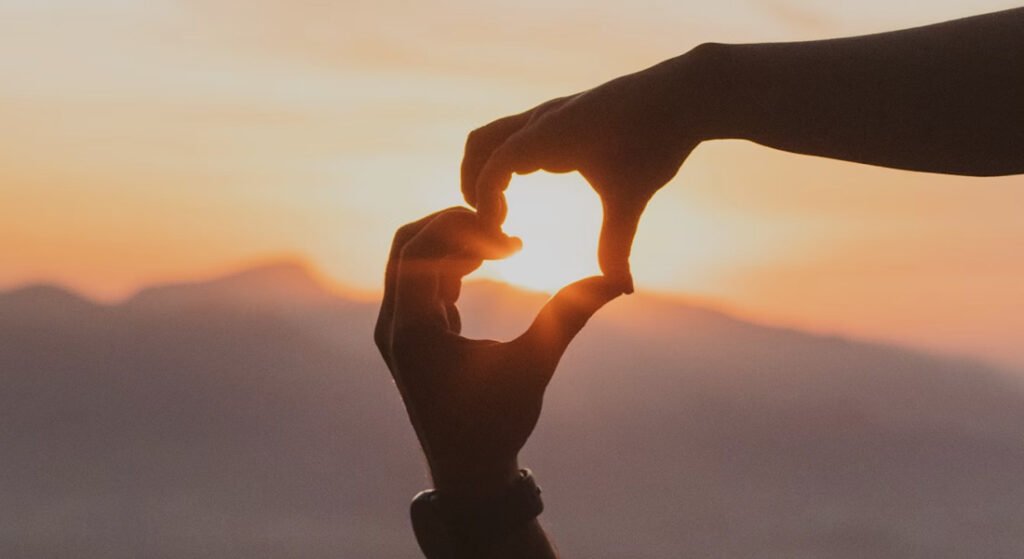 A Pedra da Gávea: Uma Aventura Imperdível no Rio de Janeiro 5 Coração com as mãos em por do sol no Rio de Janeiro.
