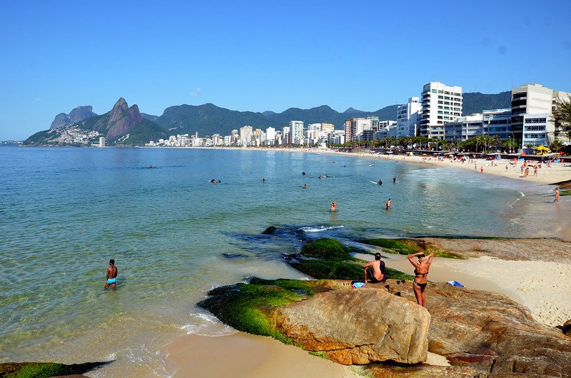 Réveillon 2025 em Copacabana: Dicas, Shows, Festas e Atrações 3 Praia do Arpoador, Rio de Janeiro. Pessoas em trajes de banho.