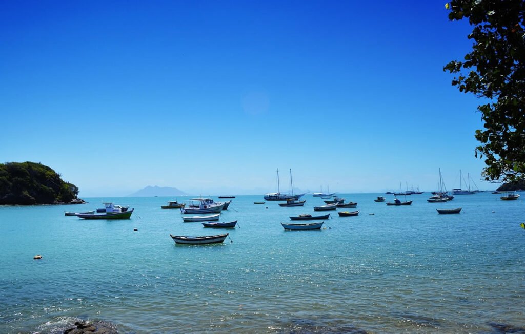 Búzios: Guia Completo para Conhecer as Melhores Praias 2 Barcos ancorados em Búzios. Mar azul, dia de sol.