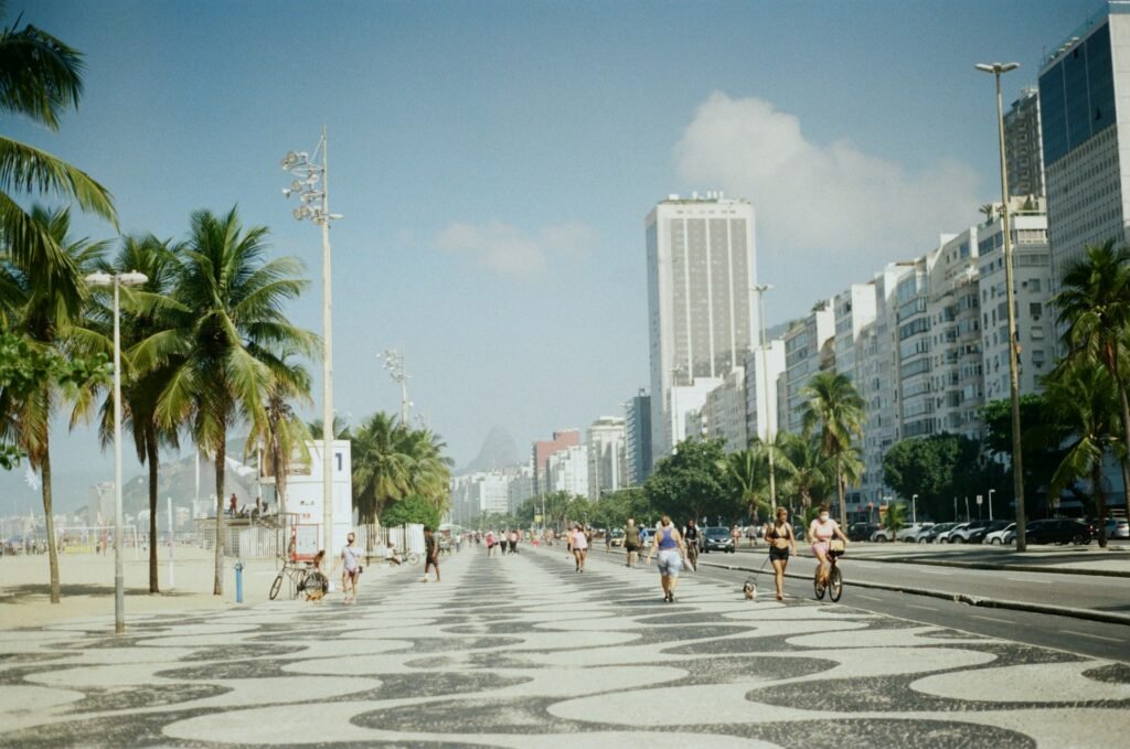 Rio de Janeiro o que você precisa saber 2024 4 Pessoas andando no calçadão da praia de Copacabana.