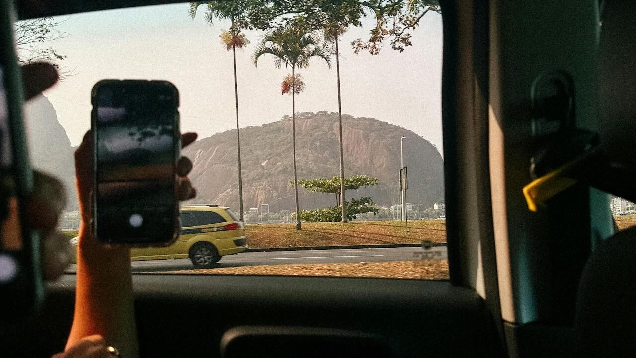 Morro da Urca Rio de Janeiro: dicas, passeios e restaurante 2 Foto de pessoa dentro de um carro vendo um táxi no Rio de janeiro pela janela do carro.
