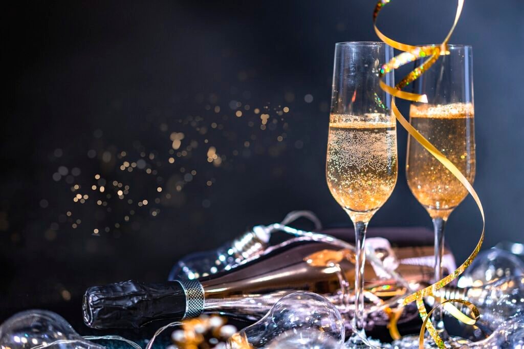 Réveillon 2025 em Búzios: O Que Fazer e Onde Ir 4 Celebração de ano novo. Bebidas e taças à mesa.