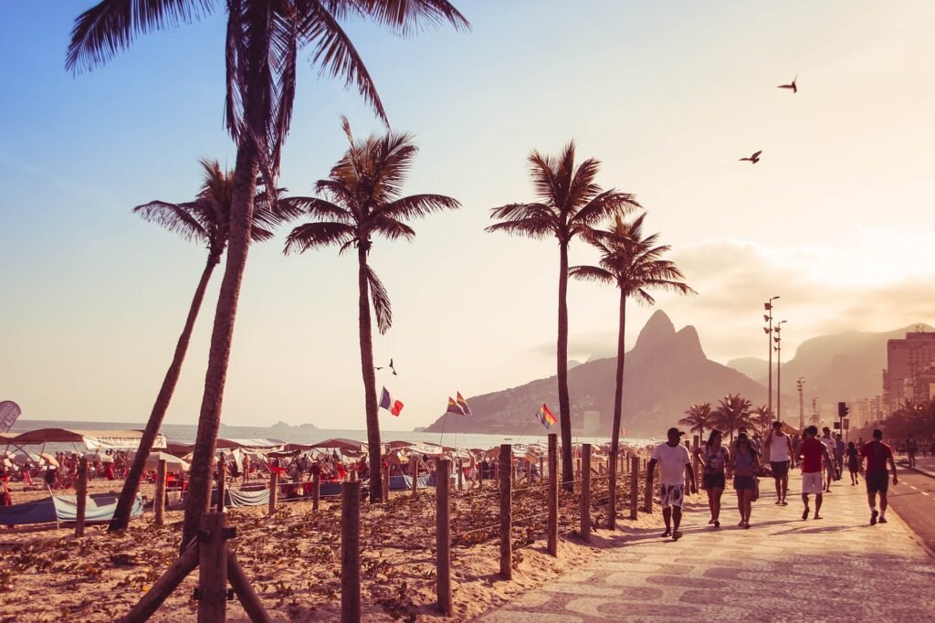 Por que o Pôr do Sol no Arpoador é o Mais Bonito do Rio de Janeiro? 5 Pessoas caminhando no calçadão da praia.