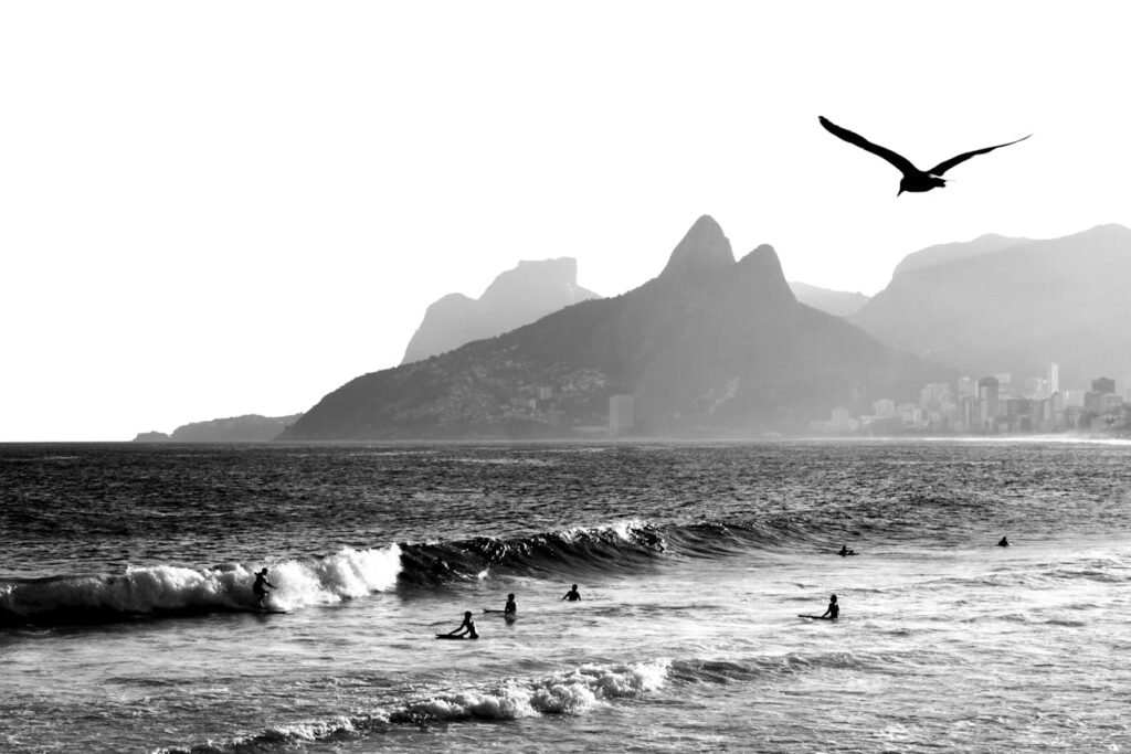 Por que o Pôr do Sol no Arpoador é o Mais Bonito do Rio de Janeiro? 4 Pessoas entrando no mar para surfar, praia do Apoador.