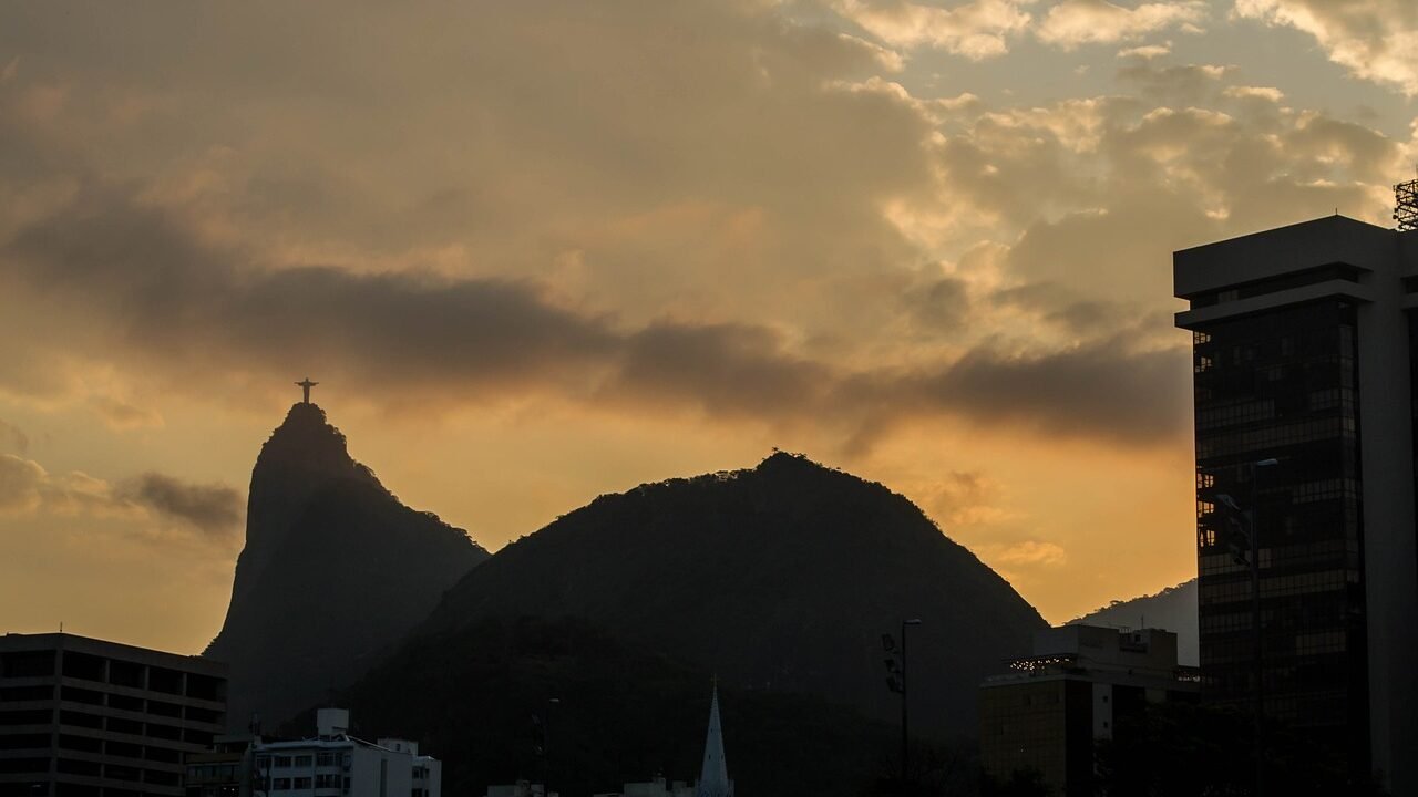 Tudo o que Você Precisa Saber Sobre o Cristo Redentor no Rio 1 Cristo Redentor, por do sol, imagem do corcovado visto de longe.