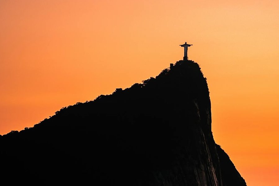 Cristo Redentor no Rio de Janeiro: O Guia para não se perder 1 Foto do Cristo Redentor, no corcovado, céu dourado no por do sol.