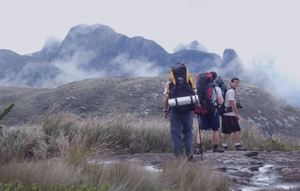 O que fazer em Teresópolis: Guia completo 3 Pessoas Fazendo trilha na Serra dos Órgãos.
