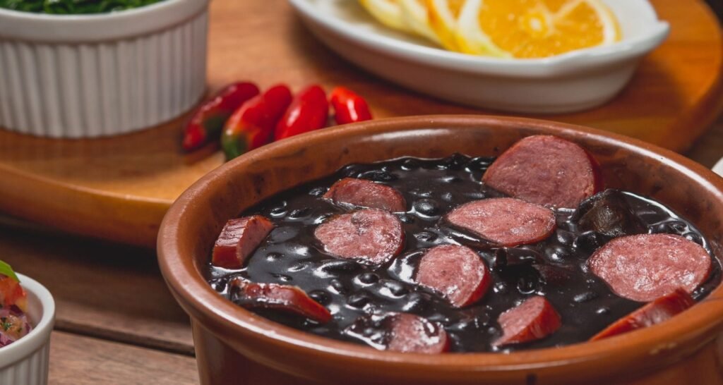 Comidas Típicas do Rio de Janeiro: o Que Comer na Cidade 10 Prato de feijoada carioca com arroz, couve, farofa, laranja e torresmo