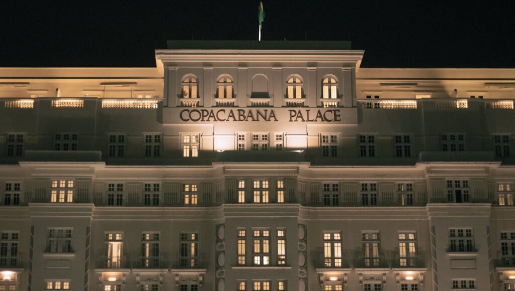 Onde se Hospedar no Rio de Janeiro: Guia por Bairro 1 Hotel Copacabana Palace iluminado à noite em frente à orla de Copacabana, Rio de Janeiro
